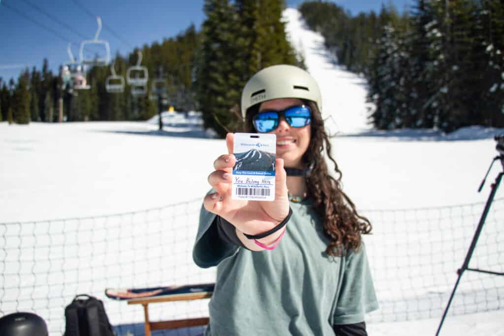 Snowboarder with a lift ticket that says You Belong Here for the 25/26 Power Pass launch